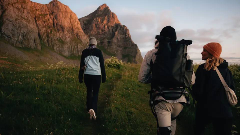 Gemeinsam unterwegs auf einem Wanderweg zwischen Bergwiesen und Felsen
